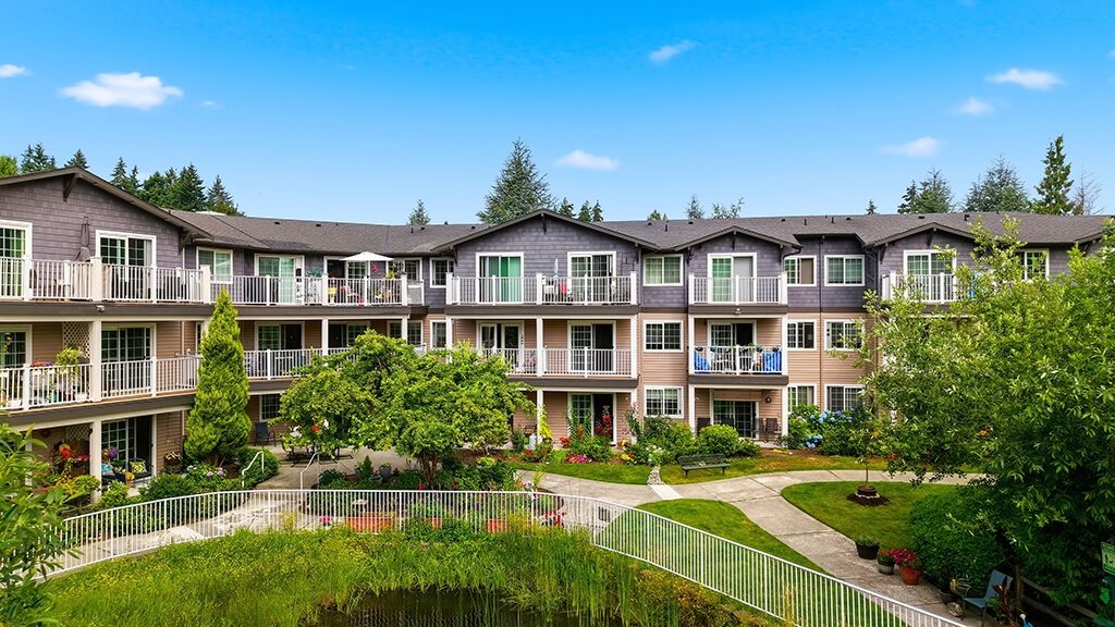 Apartment complex with greenery and a clear blue sky.